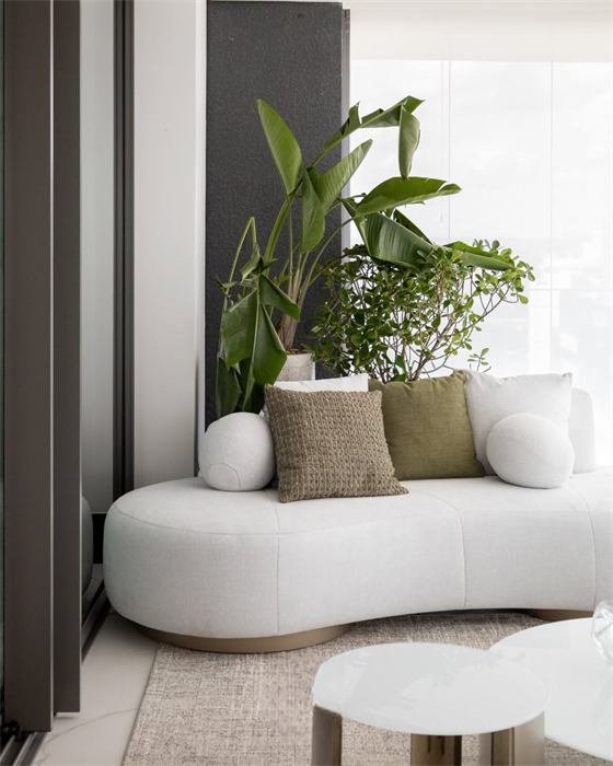 Varanda com sofá curvo branco e plantas – projeto La Glycine, Mónaco