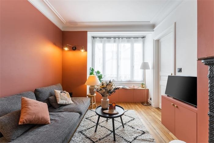 Séjour terracotta avec canapé gris et banquette sous la fenêtre – projet Rivage, Toulon